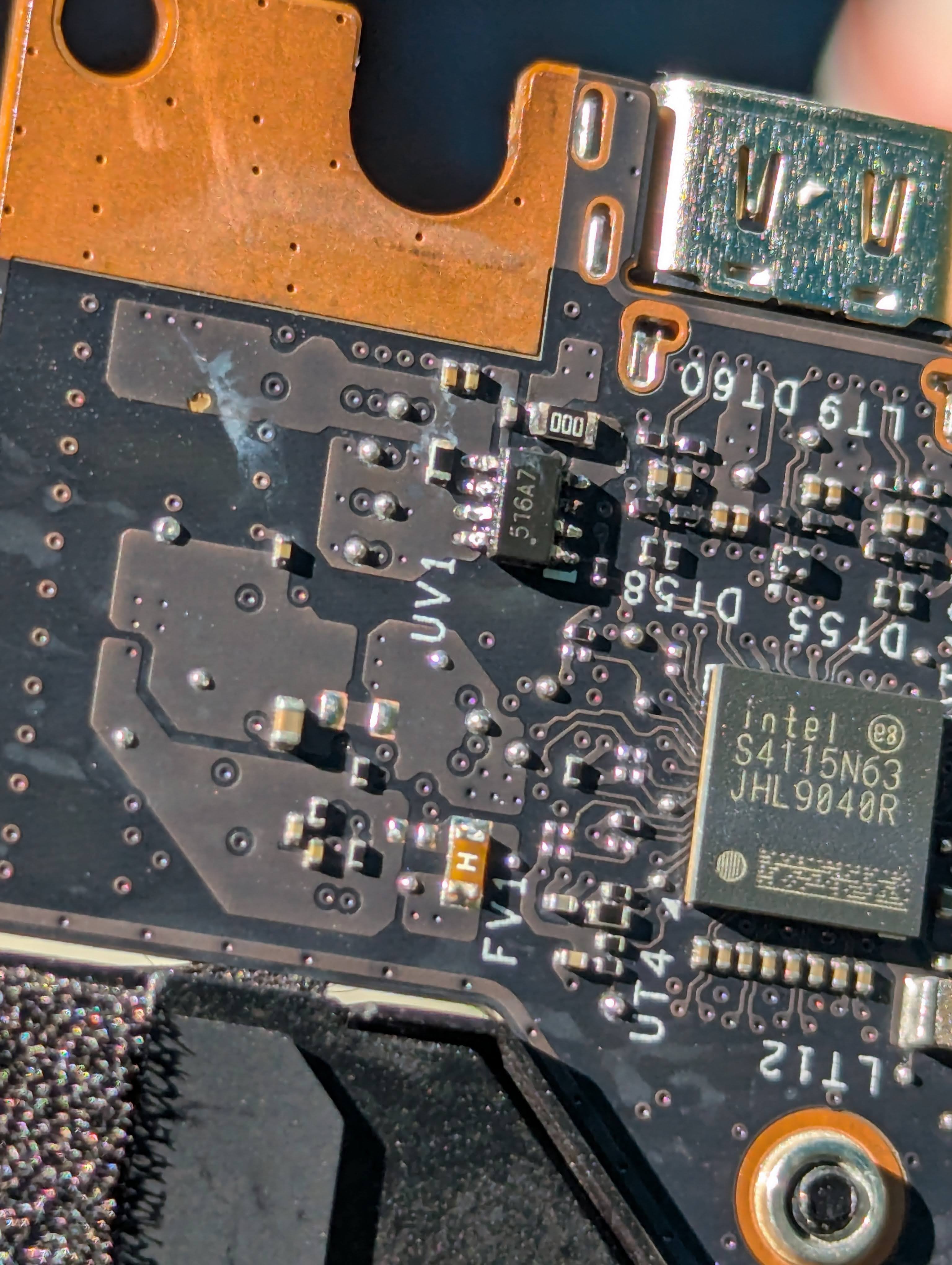 A close up of a laptop motherboard, showing the corrosion mostly removed and fresh solder applied