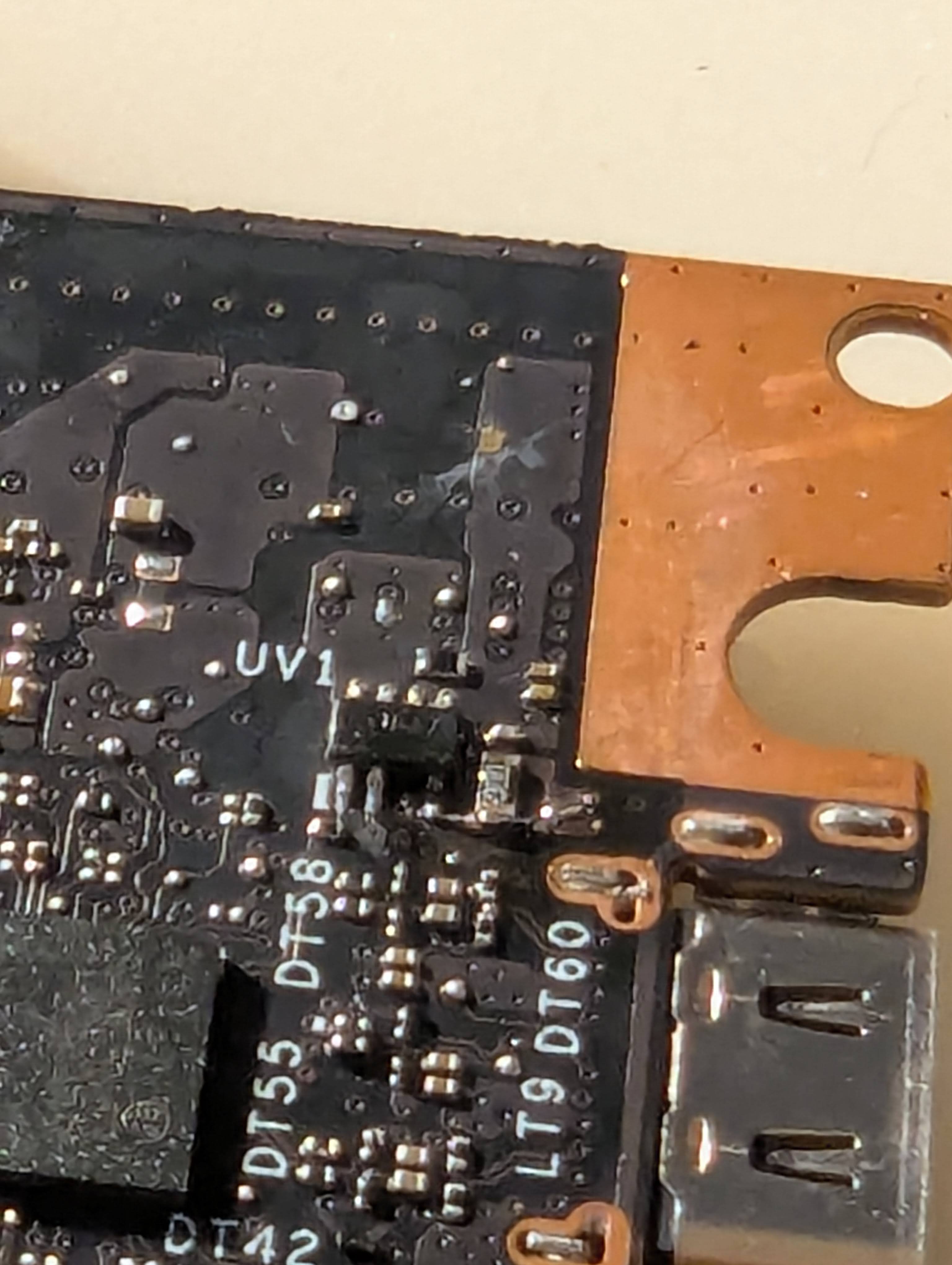 A closeup of my soldering work, with a very small wire connecting an existing trace to the chip, bypassing the 0 ohm resistor